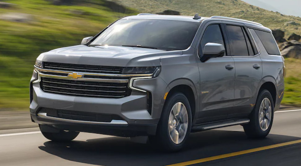 grey 2021 chevy tahoe front right angle view driving on road