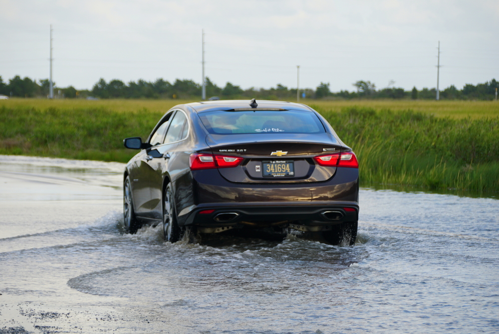 black 2021 chevy malibu driving through road with water